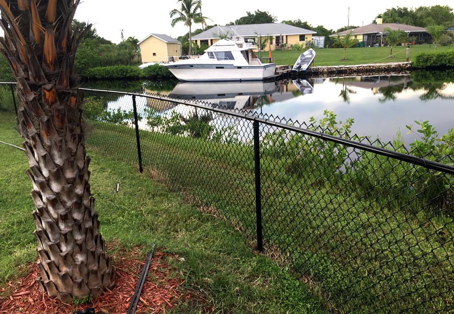 Build a chain link fence in front of a canal.