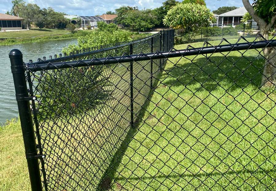 Close-up of chain link fence in front of a canal.